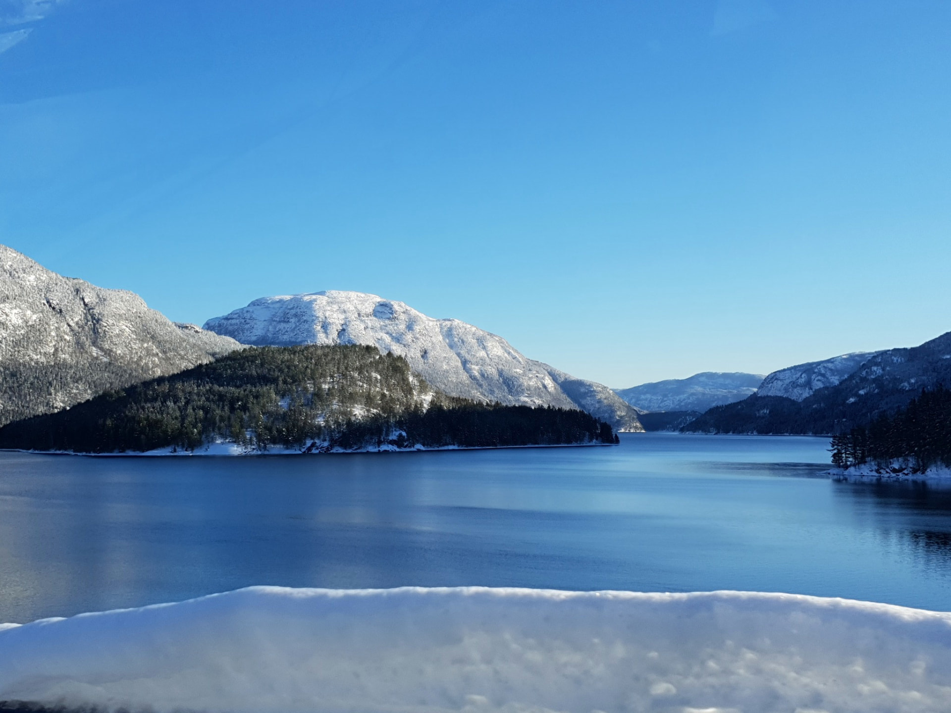 Snow-capped mountain above a blue lake